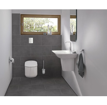 Badezimmer mit Toilette, Waschtisch, Spiegel und Fenster für eine helle, organisierte Atmosphäre