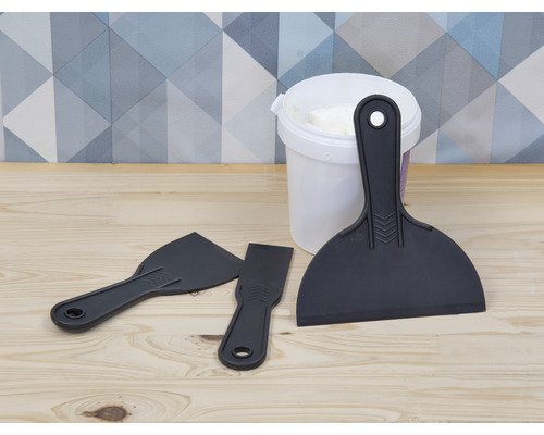 Spachtelmasse in einem Eimer mit drei Kunststoffspachteln