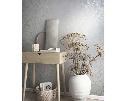 Szene mit floral gemusterter Tapete, Holztisch, Dekoration und Korb