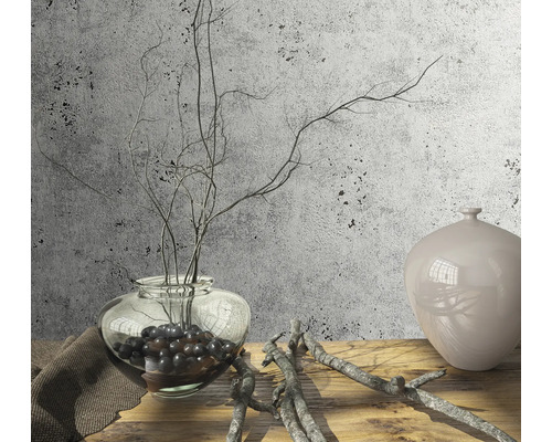 Dekorative Szene mit einer Glasvase, Zweigen und einer Keramikvase auf einem Holztisch