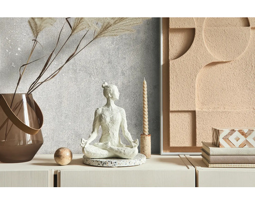 Dekorative Szene mit einer Meditationsfigur, einer Vase, einer Kerze und einem Wandbild auf einer Kommode.