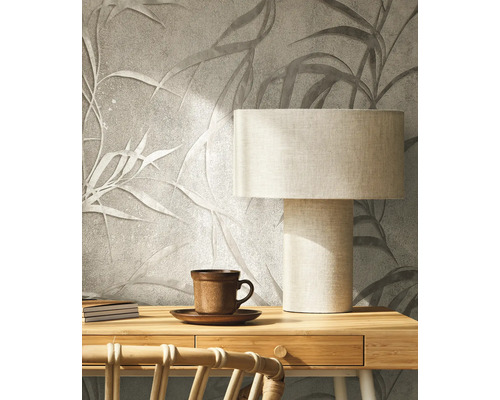 Dekorative Wand mit Blättermuster, Schreibtischlampe und Teetasse für eine gemütliche Raumatmosphäre