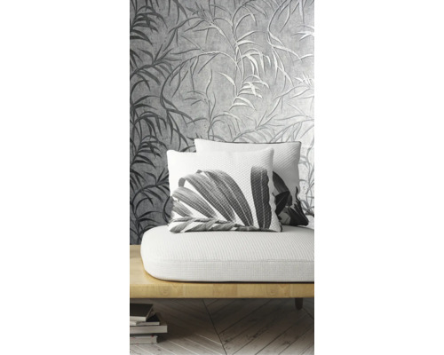 Dekoratives Wohnzimmer mit einer gemusterten Tapete und Kissen mit Pflanzenmotiven auf einem Sofa