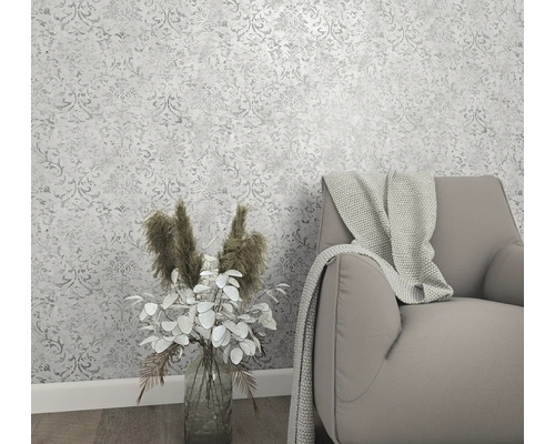 Innenraum mit gemusterter Tapete, Sessel und Blumenvase