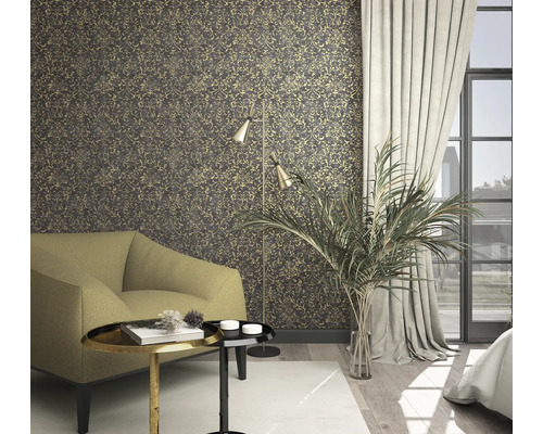 Wohnzimmer mit gemusterter Tapete, Sessel, Stehlampe und Zimmerpflanze