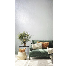 Wohnzimmer mit grüner Couch, Kissen, Beistelltischen und Dekorationen für eine helle und einladende Atmosphäre.