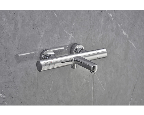 Aufputz-Brausearmatur vor grauer Wand mit Wasserfluss