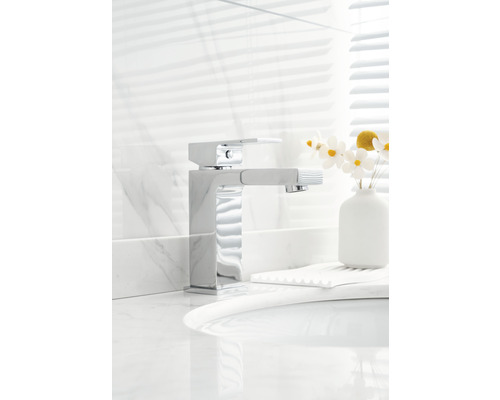 Verchromte Waschtischarmatur mit herausziehbarer Handbrause auf einem Waschtisch