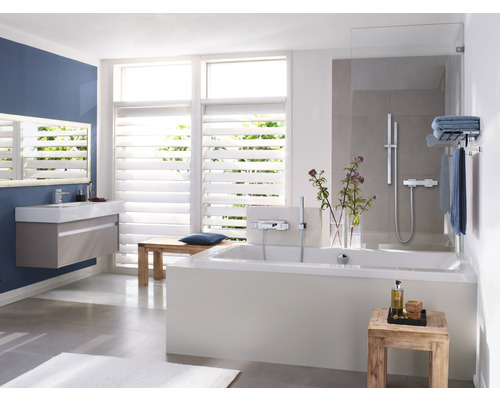 Helles Badezimmer mit Badewanne, Waschbecken und Fenster mit Jalousien
