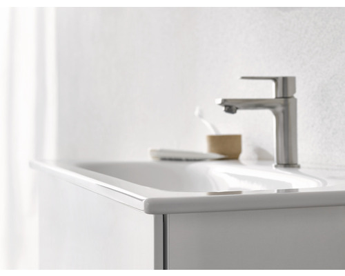 Detailansicht eines Waschbeckens mit Armatur, Seifenschale und Zahnputzbecher im Badezimmer