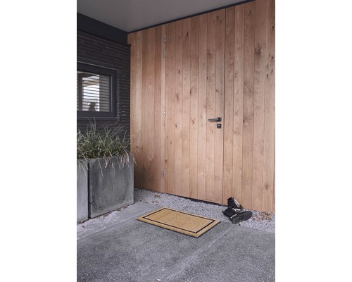 Eingangsbereich mit Fußmatte vor einer Holztür