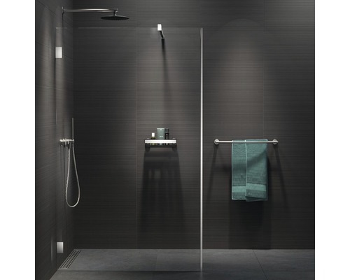 Begehbare Dusche mit Kopfbrause, Handbrause, Ablage und Handtuchhalter in einem modern gefliesten Badezimmer