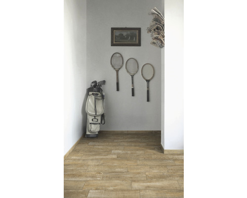 Flur mit Holzboden, Tennisschlägern an der Wand, Golfschlägern und Zeitungen