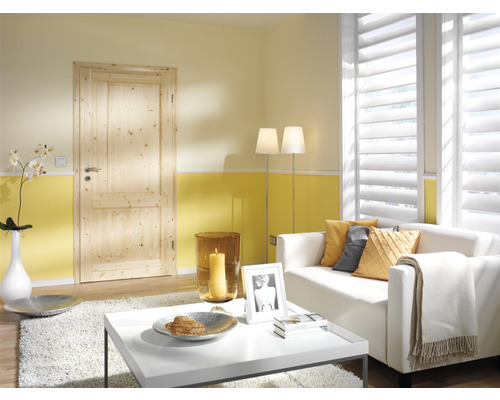 Wohnzimmer mit Holztür, Sofa und Lamellenfenster für ein helles, gemütliches Ambiente.