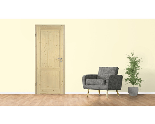 Holztür in einer Inneneinrichtung mit Sessel und Zimmerpflanze
