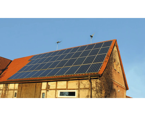 Hausdach mit Solaranlage und zwei Windrädern zur Energiegewinnung