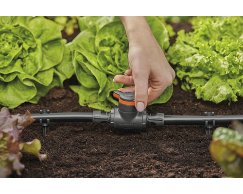 Gardena Micro-Drip-System mit Hand im Gartenbeet zur Bewässerung von Pflanzen