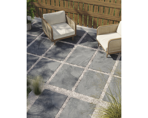 Terrasse mit Steinplatten und Kiesflächen sowie zwei Sesseln
