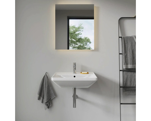 Modernes Badezimmer mit Waschbecken, beleuchtetem Spiegel und Handtuchhalter.