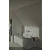 Badezimmer mit Badewanne unter Dachschräge, Armatur und kleinem Tisch