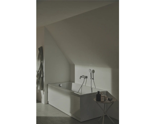 Badezimmer mit Badewanne unter Dachschräge, Armatur und kleinem Tisch