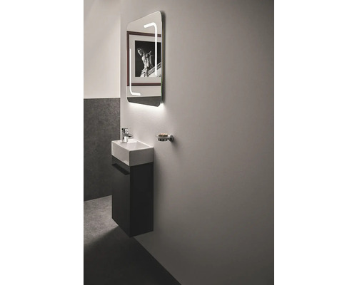 Badezimmer mit Waschtisch, beleuchtetem Spiegel und Seifenschale