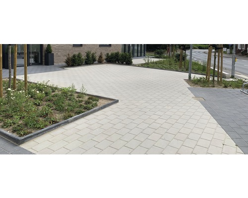 Gepflasterte Fläche mit Betonsteinen und Rabatten