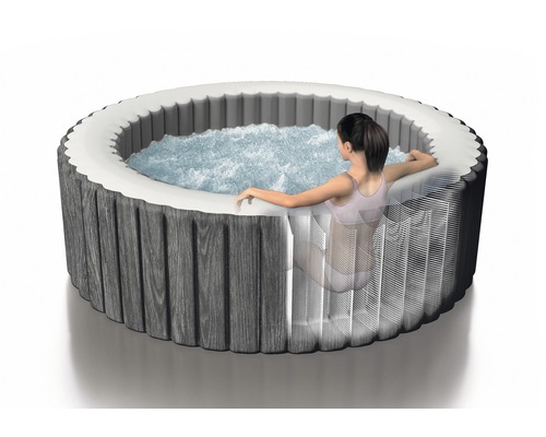 Runder Whirlpool mit Holzverkleidung und einer Person
