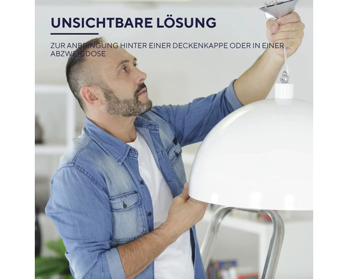 Ein Mann montiert eine Lampe an der Decke.