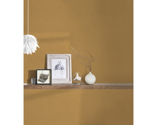 Einrichtungsgegenstände auf einem Wandregal vor einer strukturierten Wand