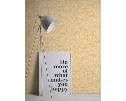 Nahaufnahme einer Wand mit einer strukturierten Tapete, einer Stehlampe und einem gerahmten Poster mit einer motivierenden Botschaft.