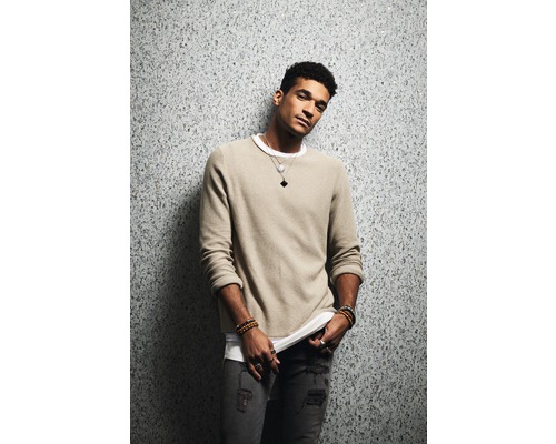 Mann in Pullover, T-Shirt und Jeans