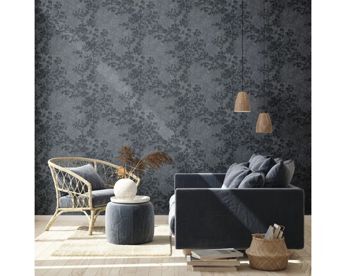 Wohnraum mit floral gemusterter Tapete, Sessel und Sofa