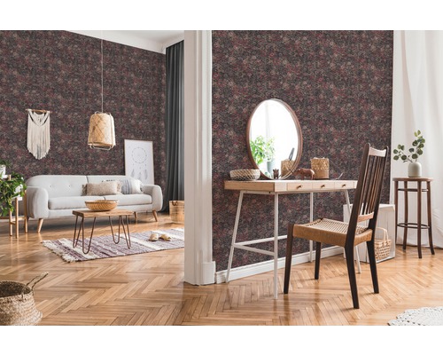 Wohnzimmer mit gemusterter Tapete, Sofa, Tisch und Dekorationen für ein gemütliches Ambiente.