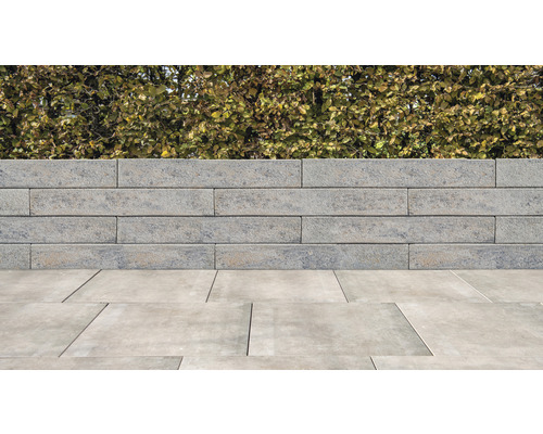 Betonsteinmauer mit Pflastersteinen im Gartenbereich
