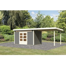 Gartenhaus mit Anbau auf gepflasterter Fläche vor Gartenszenerie.