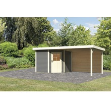 Gartenhaus mit Anbau auf gepflasterter Fläche vor Büschen und Bäumen