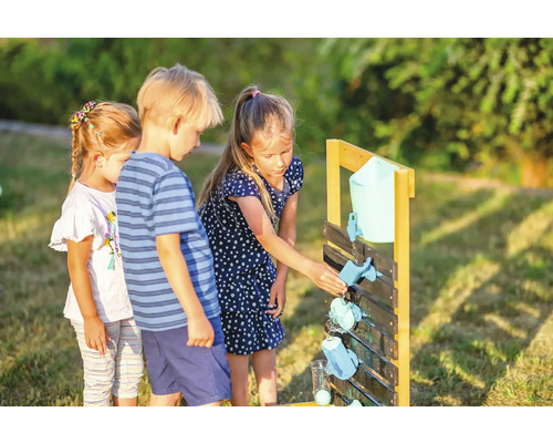 Kinder spielen mit einer Wasserspielbahn aus Holz im Garten.