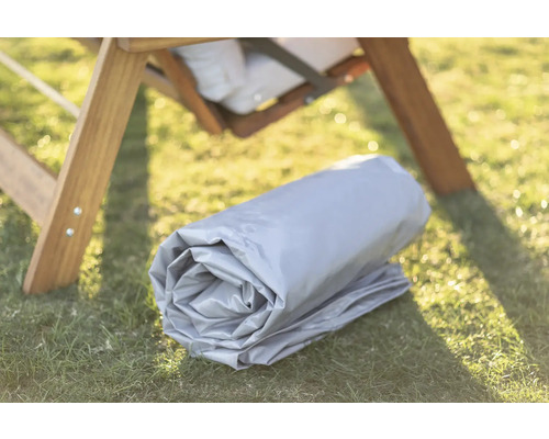 Gerollte Schutzhülle auf Rasen unter einem Holzstuhl