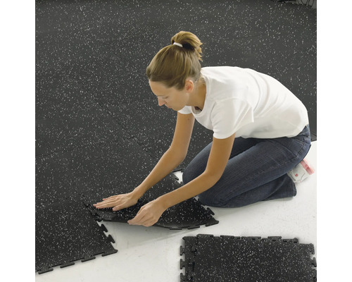 Frau verlegt Verbundfliesen im Innenraum