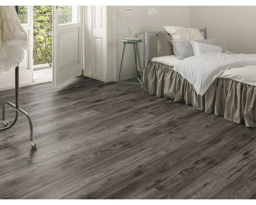 Schlafzimmer mit Laminatboden in Holzoptik, Bett und Balkontür