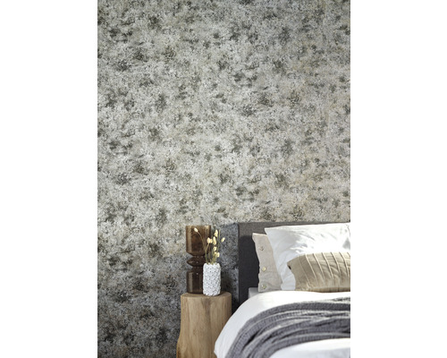 Schlafzimmer mit gemusterter Tapete, Bett und Beistelltisch aus Holz