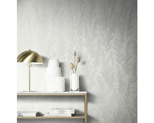 Wandgestaltung mit strukturierter Tapete mit Pflanzenmuster, Tisch mit Dekoration und Lampe