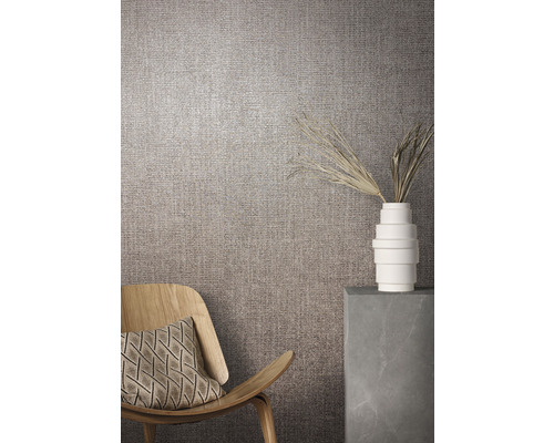 Wohnraumszene mit Textiltapete, Sessel und Dekoration