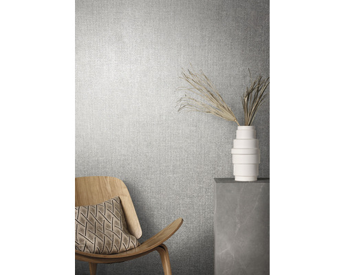 Raumszene mit Textiltapete, Sessel und Dekoration