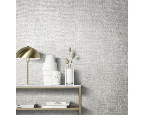 Nahaufnahme einer strukturierten Tapete in einem hellen Raum mit Tisch, Lampe und Dekoration