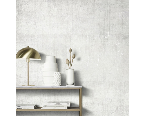 Dekoratives Zimmer mit Lampe, Vasen und Büchern auf einem Tisch vor einer strukturierten Wand