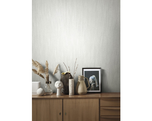 Tapete mit Textilmuster im Wohnraum auf Holzkommode mit Dekoration