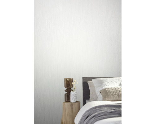 Wohnraum mit Bett und gemusterter Tapete an der Wand