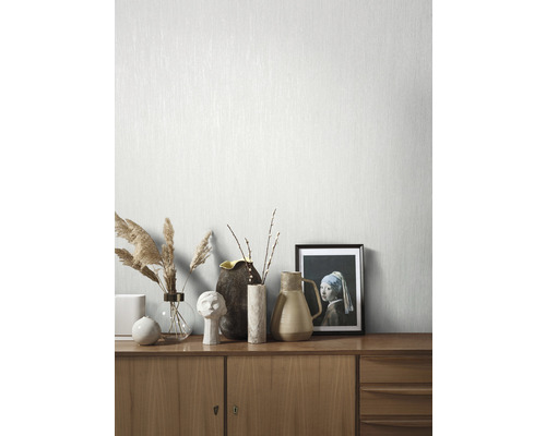 Helle, strukturierte Tapete an einer Wand mit Sideboard und Dekoration